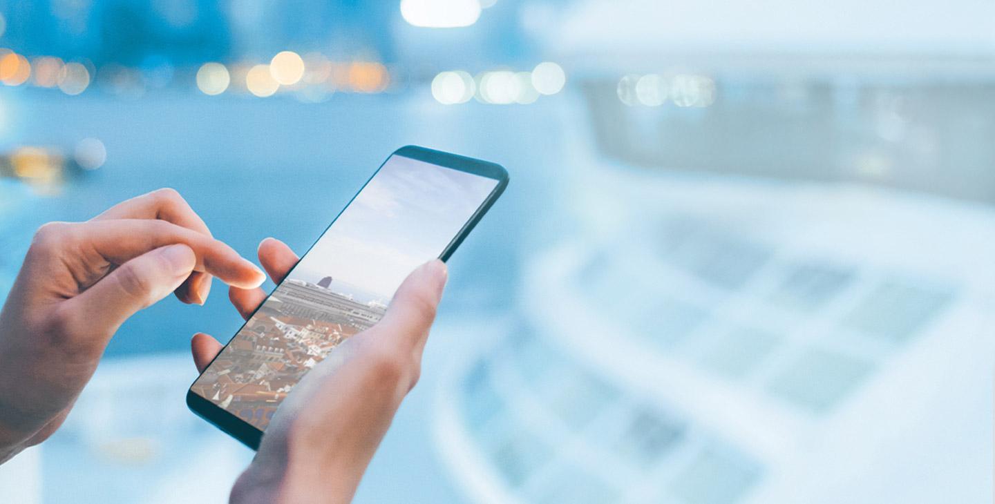 Close up of a woman's hand using a smart phone on a yacht